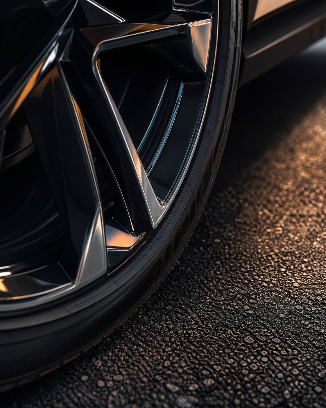 Detail de jante de voiture et pneu sur asphalte avec reflets chromes