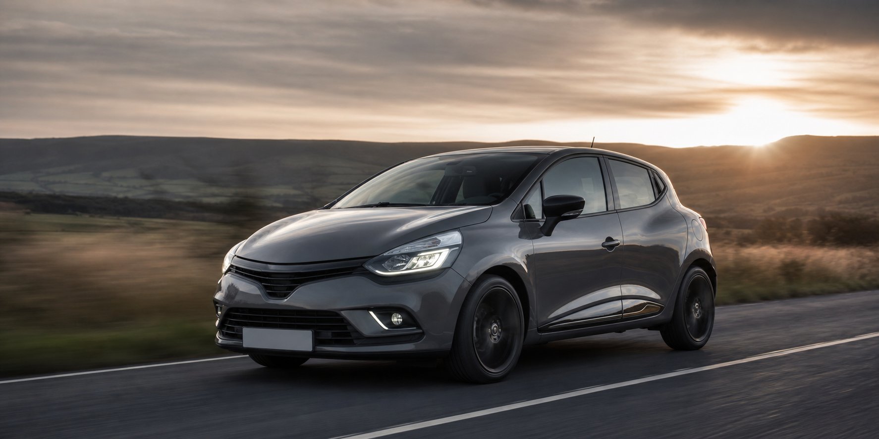 Renault Clio 4 grise sur route de campagne vue laterale